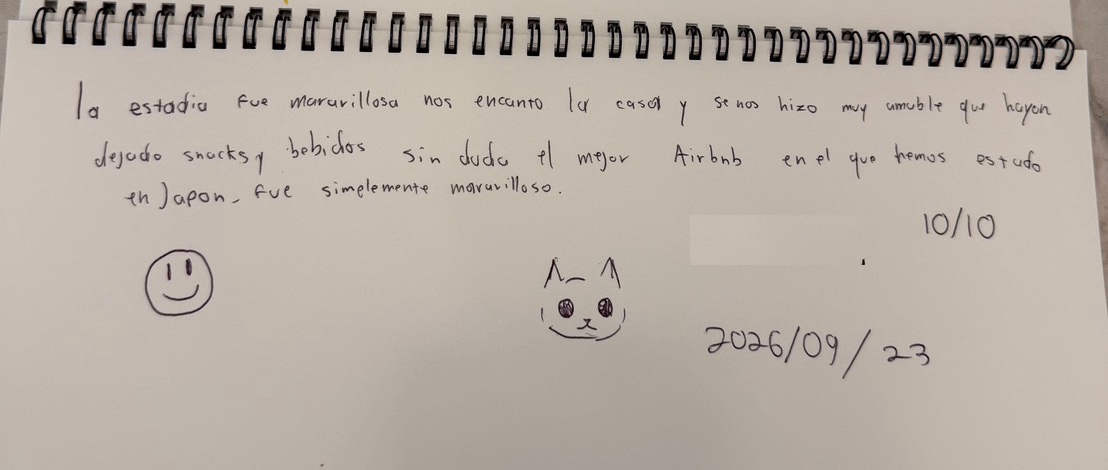 住客在留言本上的手寫西班牙文留言，附笑臉與小貓塗鴉